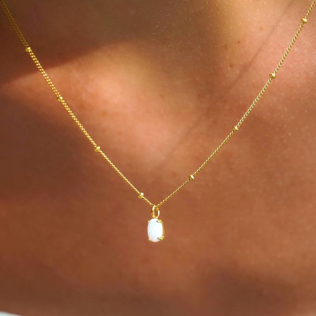 Collar de cuentas doradas con colgante de ópalo